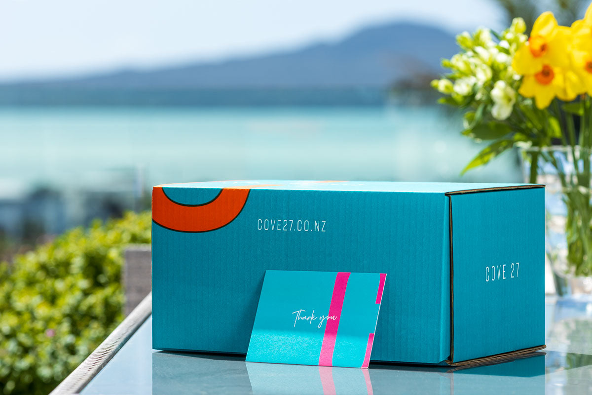 Load image into Gallery viewer, An image of a beautiful COVE 27 Premium Packaging Box with the iconic Rangitoto Island in the background.