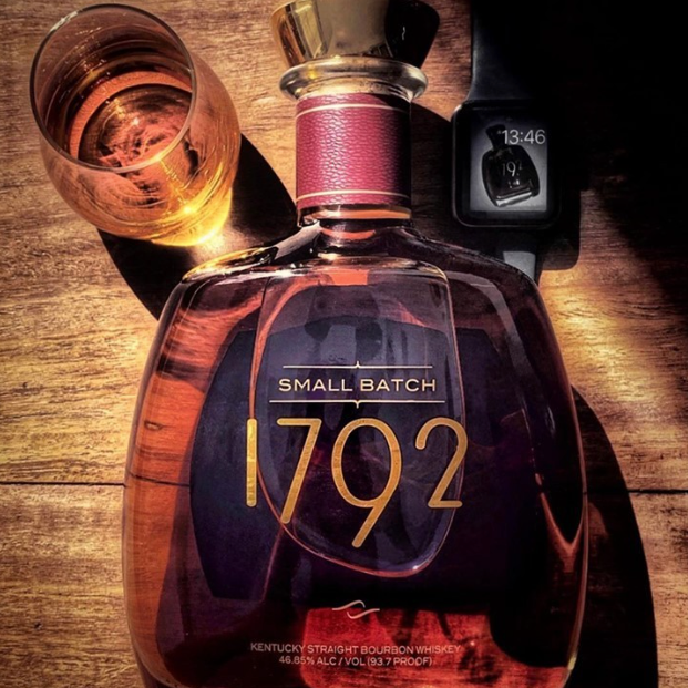 Load image into Gallery viewer, A bottle of 1792 Small Batch Kentucky Straight Bourbon Whiskey on a rustic wooden surface, next to a filled glass and a smartwatch.