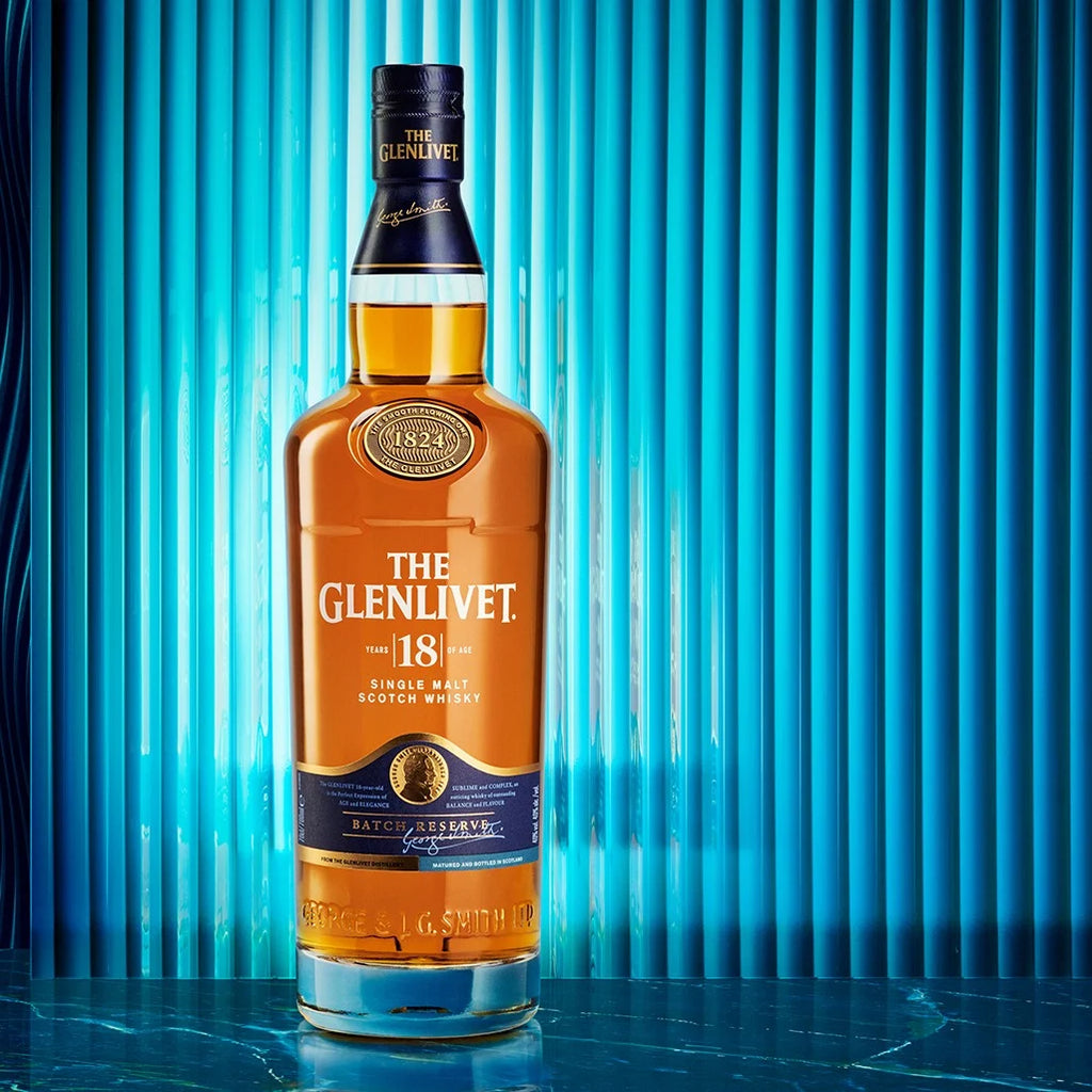 Bottle of The Glenlivet 18-year-old single malt Scotch whisky against a blue curtain background