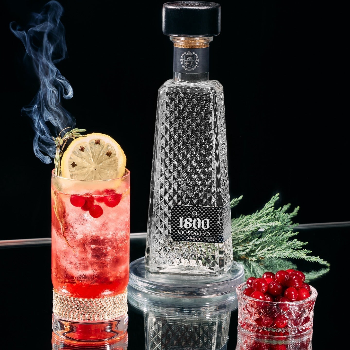 Load image into Gallery viewer, 1800 Cristalino Añejo Jose Cuervo Tequila bottle with a cocktail and garnishes on a black background