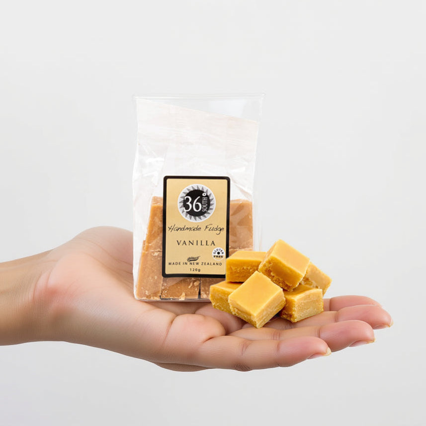 Load image into Gallery viewer, Hand holding a package of 36 degrees vanilla fudge with a clear background