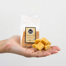 Load image into Gallery viewer, Hand holding a package of 36 degrees vanilla fudge with a clear background