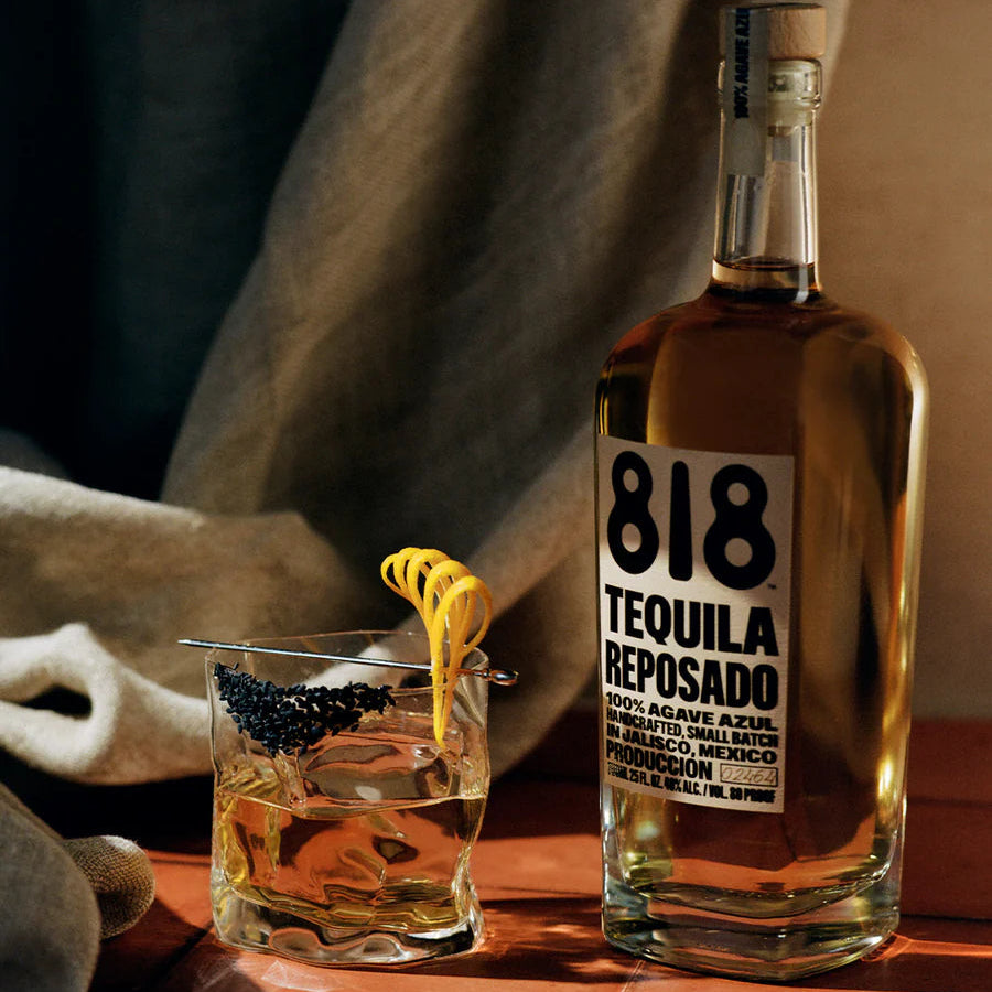 Load image into Gallery viewer, 818 Tequila Reposado bottle with a cocktail on a wooden surface