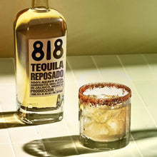 Load image into Gallery viewer, 818 Tequila Reposado bottle with a glass of margarita on a tiled surface.