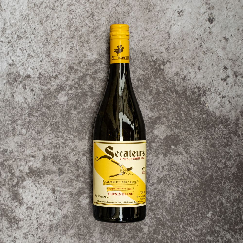 Wine bottle with yellow label on a textured gray background