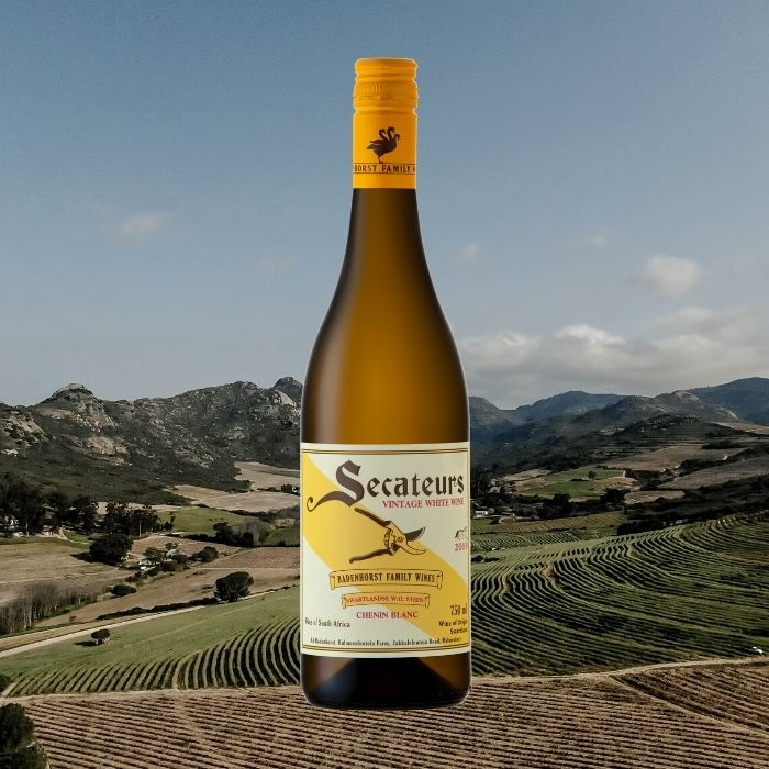 Secateurs wine bottle with a scenic background of mountains and vineyards