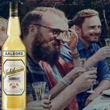 Load image into Gallery viewer, Aalborg Jubilaeums bottle with people enjoying a drink in the background