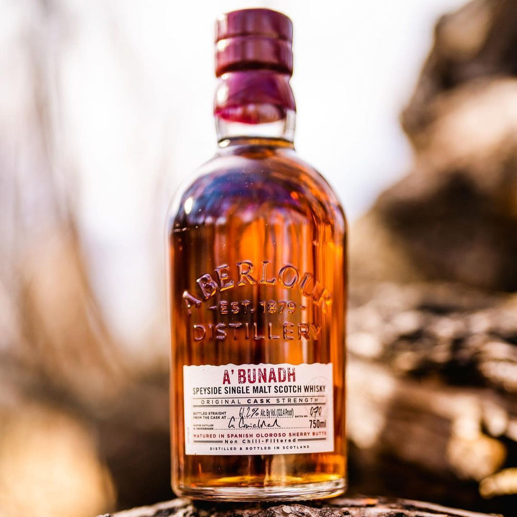 Bottle of Aberlour Abunadh whisky on a wooden surface with a blurred natural background