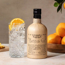 Load image into Gallery viewer, Bathtub Gin bottle with a glass of gin and tonic and oranges on a wooden surface.