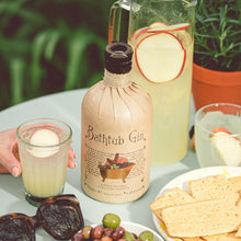 Load image into Gallery viewer, Bottle of Bathtub Gin with a glass of gin and tonic, olives, and crackers on a table.