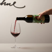 Load image into Gallery viewer, Person pouring Adelina Wines Grenache wine red wine from a decorative bottle into a glass against a neutral background