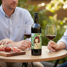 Load image into Gallery viewer, Two people sitting at a table with a bottle of Adelina Wines Grenache wine red wine and glasses outdoors.
