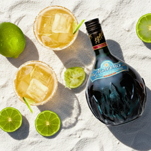 Load image into Gallery viewer, Bottle of Jose Cuervo on a sandy surface with lime wedges and two cocktails.