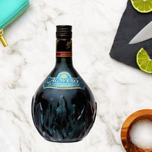 Load image into Gallery viewer, Agavero Tequila Liqueur bottle with limes and a knife on a marble surface