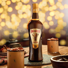 Load image into Gallery viewer, Amarula cream bottle on a table with blurred lights in the background