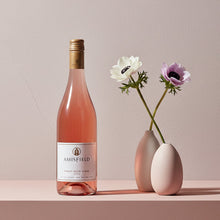 Load image into Gallery viewer, Bottle of Amisfield rosé wine with two small vases containing flowers on a pink surface.