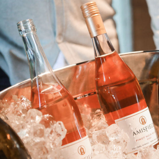 Amisfield wine bottles in a bucket of ice, with a blurred background