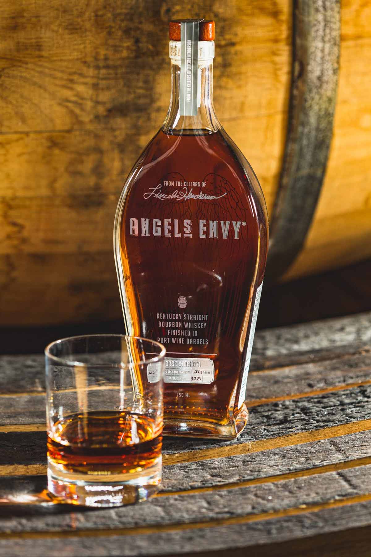 Load image into Gallery viewer, Angel's Envy Kentucky Straight Bourbon Whiskey with a tumbler of bourbon infront of a barrell