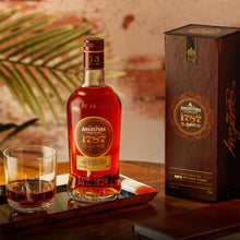 Load image into Gallery viewer, Angostura 1787 15-year-old rum bottle and box on a table with a glass of rum.