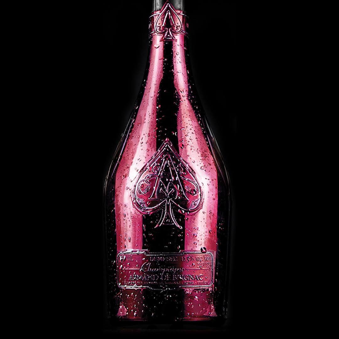Load image into Gallery viewer, A close up image of a pink bottle of Armand de Brignac Ace of Spades Rosé Champagne with a dark background.
