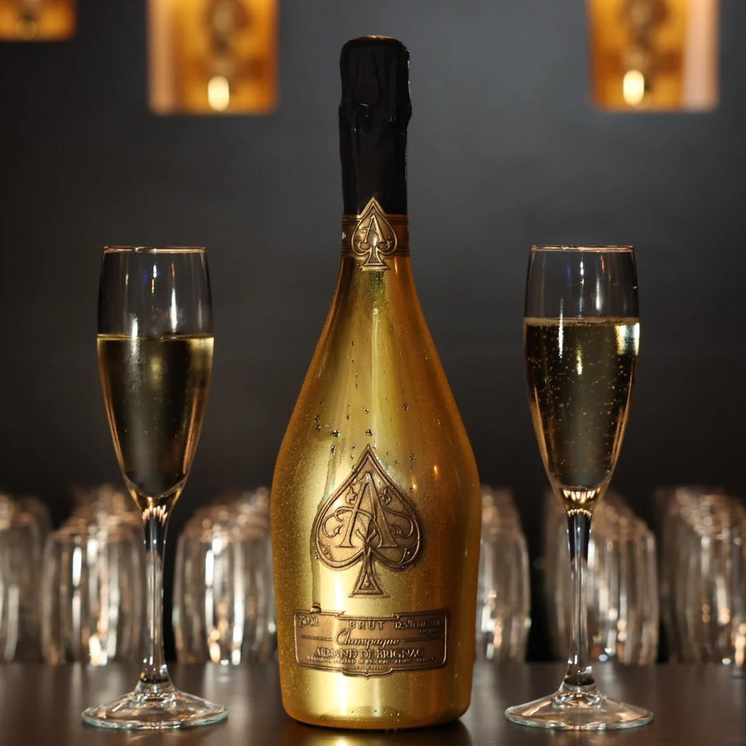 Load image into Gallery viewer, Gold champagne bottle with two glasses on a dark background