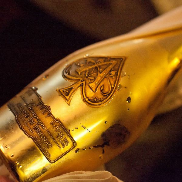 Load image into Gallery viewer, Close-up of a gold bottle of Armand de Brignac champagne