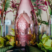 Load image into Gallery viewer, Rose gold bottle with brand logo surrounded by flowers