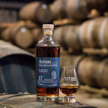Load image into Gallery viewer, Arran 17 year old whisky bottle and glass on barrels with a blurred background