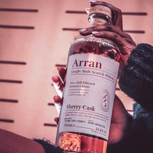 Load image into Gallery viewer, Person holding a bottle of Arran Sherry Cask Single Malt Scotch Whisky against a blurred background