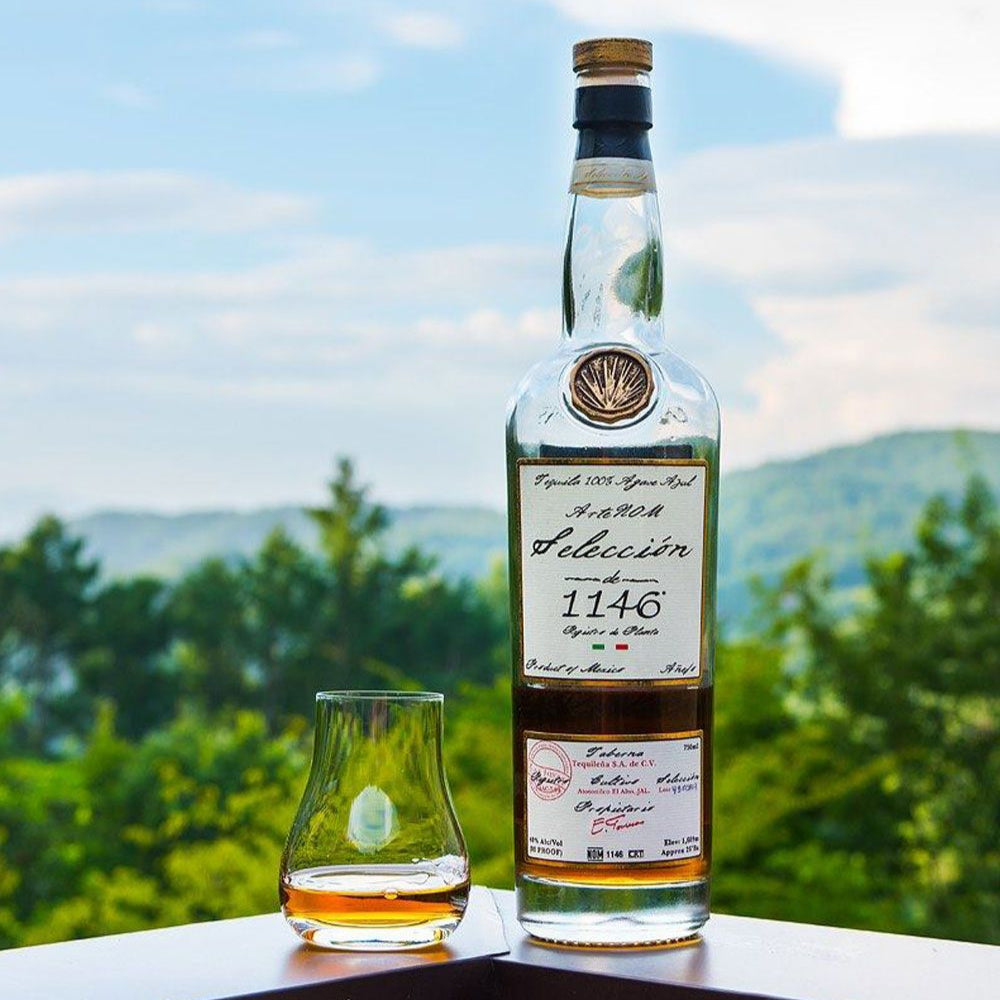 Bottle and glass of ArteNOM-Seleccion-de-1146-Anejo-Tequila 1146 with a scenic background