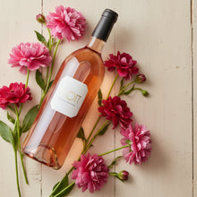 Load image into Gallery viewer, Bottle of BY.OTT Provence Rose Magnum wine surrounded by pink and red flowers on a light wooden surface