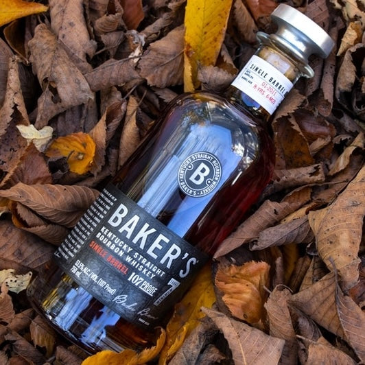 Load image into Gallery viewer, Baker's 7YO Single Barrel Kentucky Bourbon laying on autumn coloured leaves