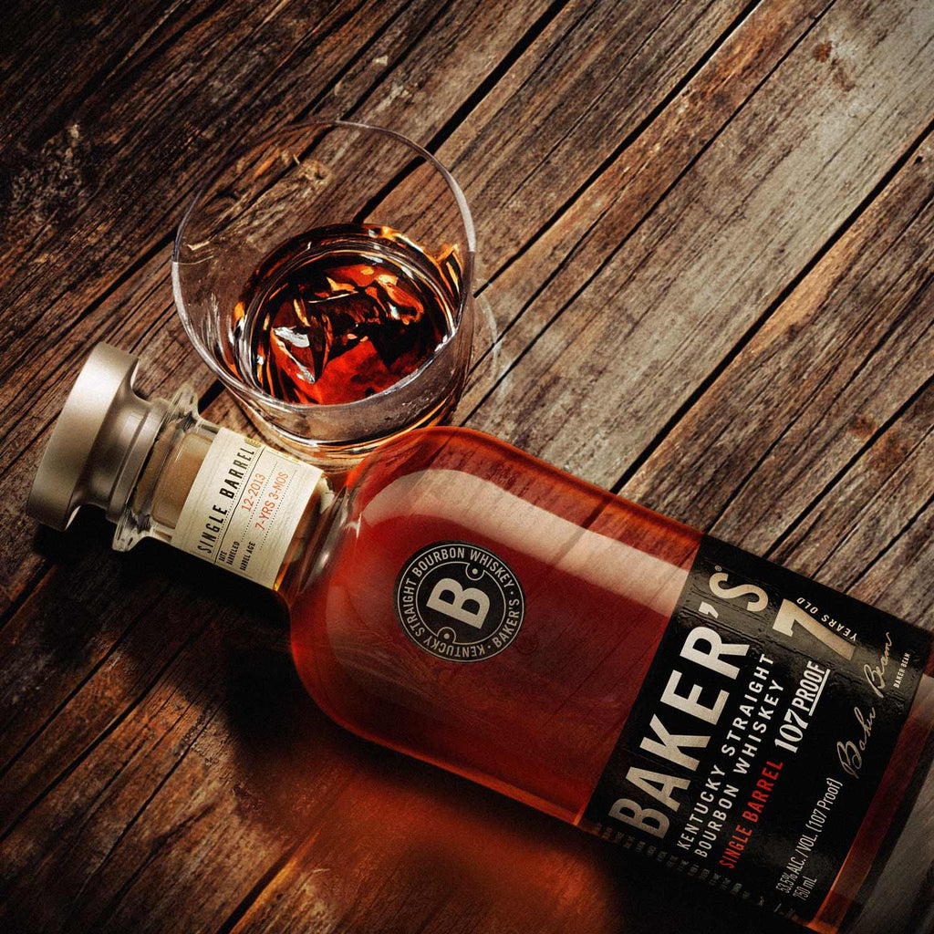 Baker's bourbon whiskey bottle and glass on a wooden surface