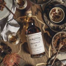 Load image into Gallery viewer, Balvenie 12 year old whisky bottle with glasses and snacks on a rustic surface
