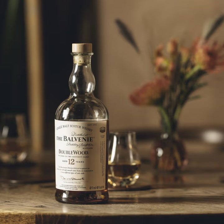 Balvenie 12 year old whiskey bottle on a wooden table with blurred background