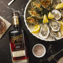 Load image into Gallery viewer, Bottle of Bayou XO RUM with a plate of oysters on a black surface