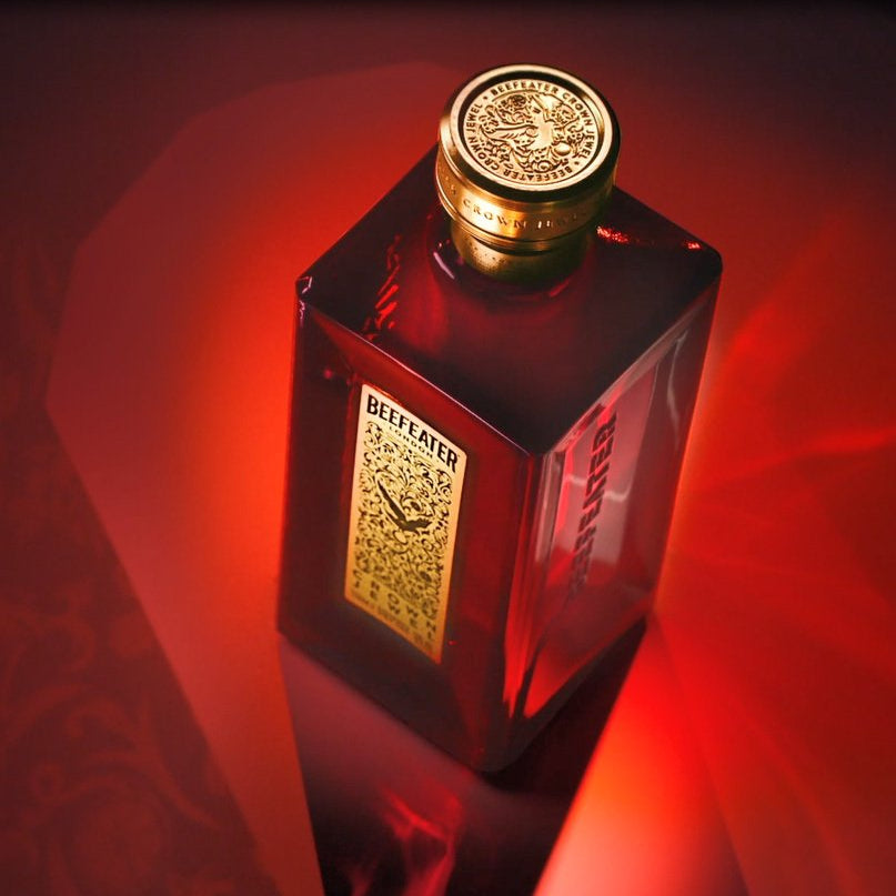 Load image into Gallery viewer, Bottle of Beefeater Crown Jewel luxury Gin with a gold cap and label on a red background