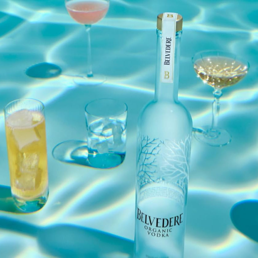 Load image into Gallery viewer, Belvedere Vodka bottle with cocktails on a pool surface