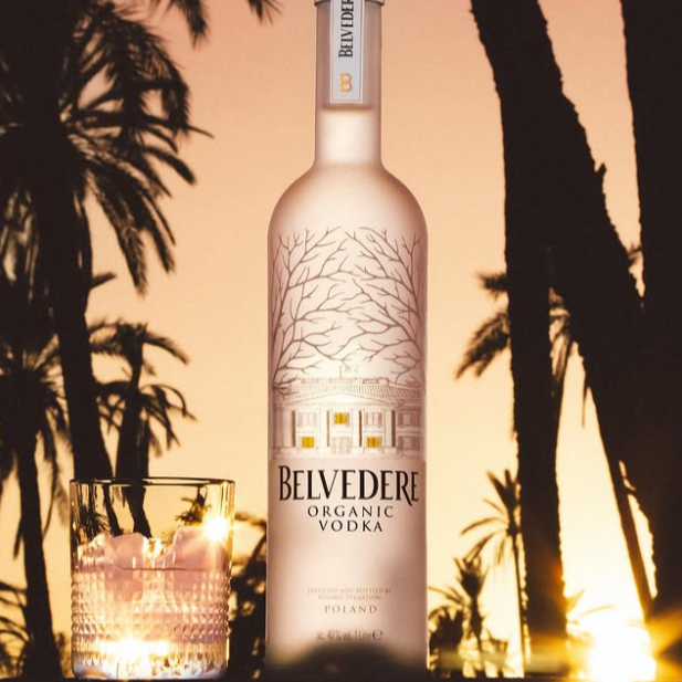 Load image into Gallery viewer, Belvedere Organic Vodka bottle with palm trees and sunset in the background