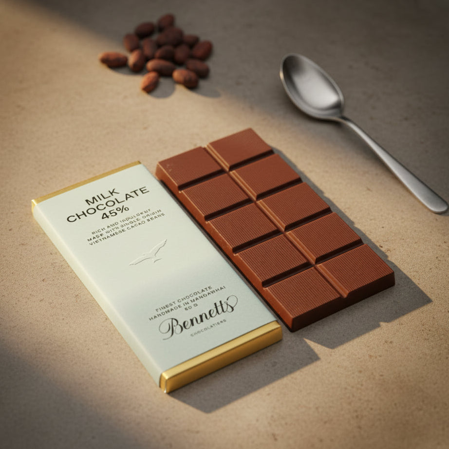 Load image into Gallery viewer, A Bennett's Milk Chocolate bar with packaging and almonds on a wooden surface