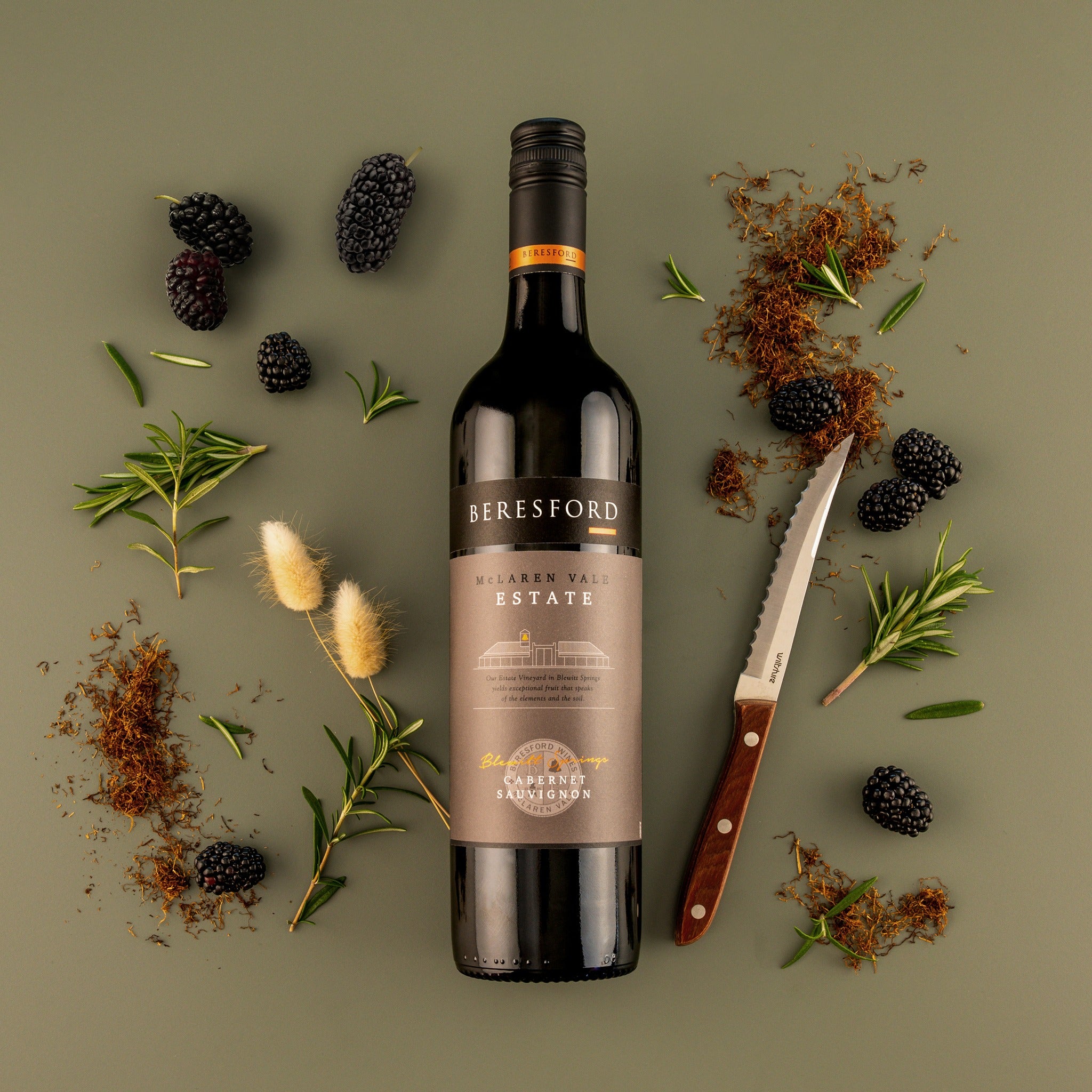 Load image into Gallery viewer, Beresford-Estate-McLaren-Vale-Shiraz bottle with blackberries, herbs, and a knife on a green background
