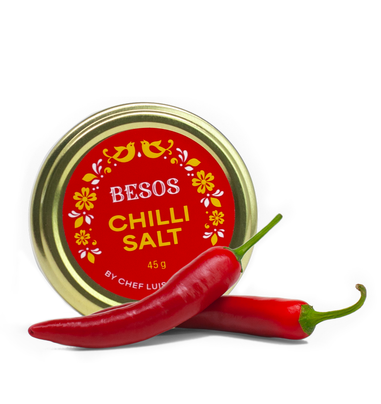 Load image into Gallery viewer, A jar of Besos Chilli Salt by Chef Luis Cabrera next to two fresh red chillis.