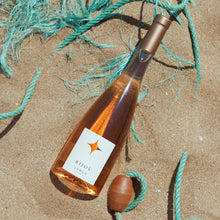 Load image into Gallery viewer, Bottle of BIJOU LUMEA PROVENCE ROSE wine with a label on a sandy surface with ropes and shells.
