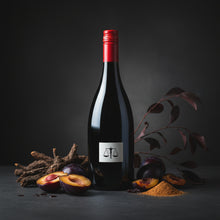 Load image into Gallery viewer, A bottle of Bilancia La Collina Syrah wine red wine bottle with a label featuring a balance scale, surrounded by plums and spices on a dark background.