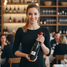 Load image into Gallery viewer, Woman holding a bottle of Bilancia La Collina Syrah wine in a restaurant setting