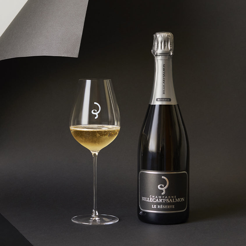 Load image into Gallery viewer, Bottle and glass of Billecart-Salmon Le Reserve Champagne on a black and Gary background
