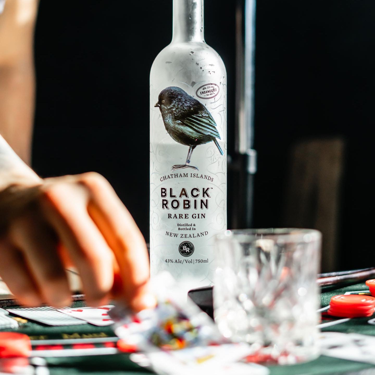 Load image into Gallery viewer, Black Robin Rare Gin bottle on a table with a blurred background