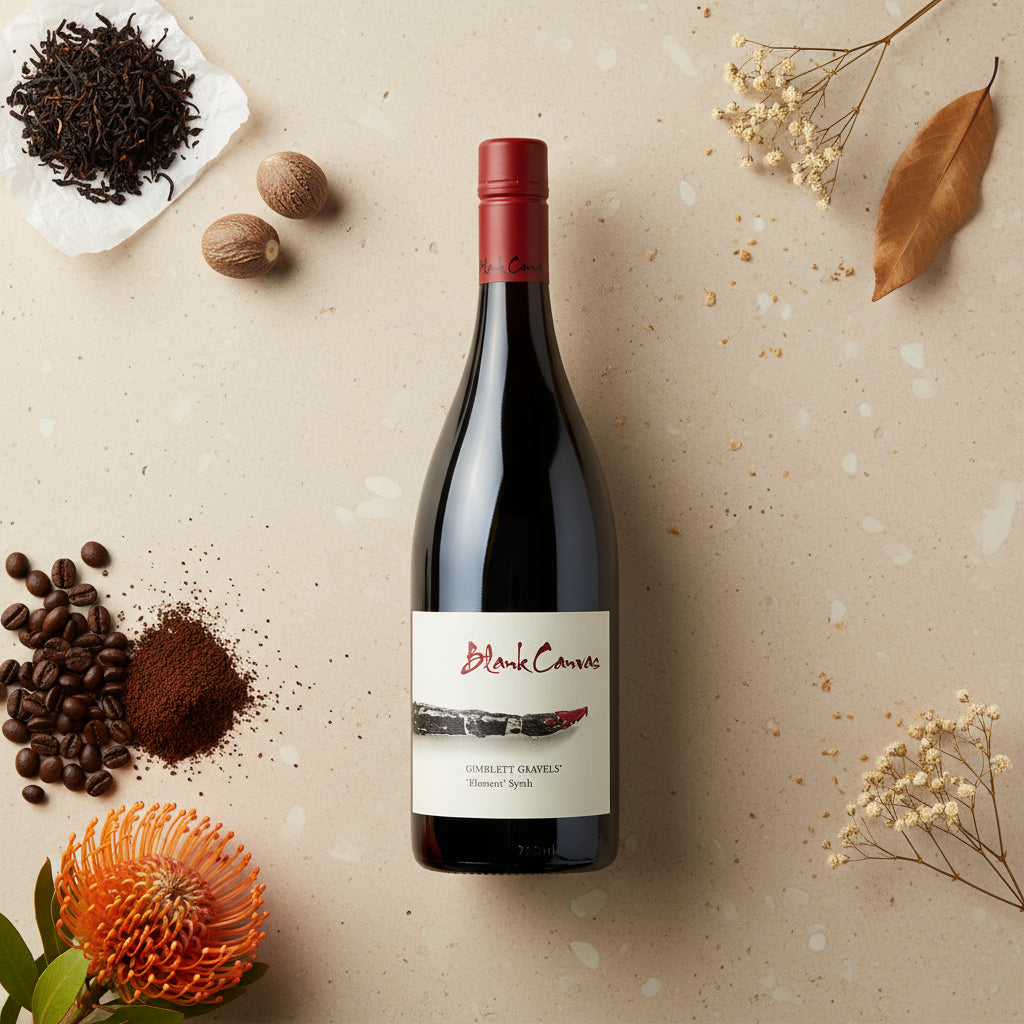 Load image into Gallery viewer, Blank-Canvas-Element-Syrah red wine bottle with a label on a beige surface with coffee beans, flowers, and nuts.