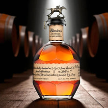 Load image into Gallery viewer, Bottle of Blanton&#39;s Single Barrel Bourbon Whiskey with a horse emblem on a wooden barrel background.