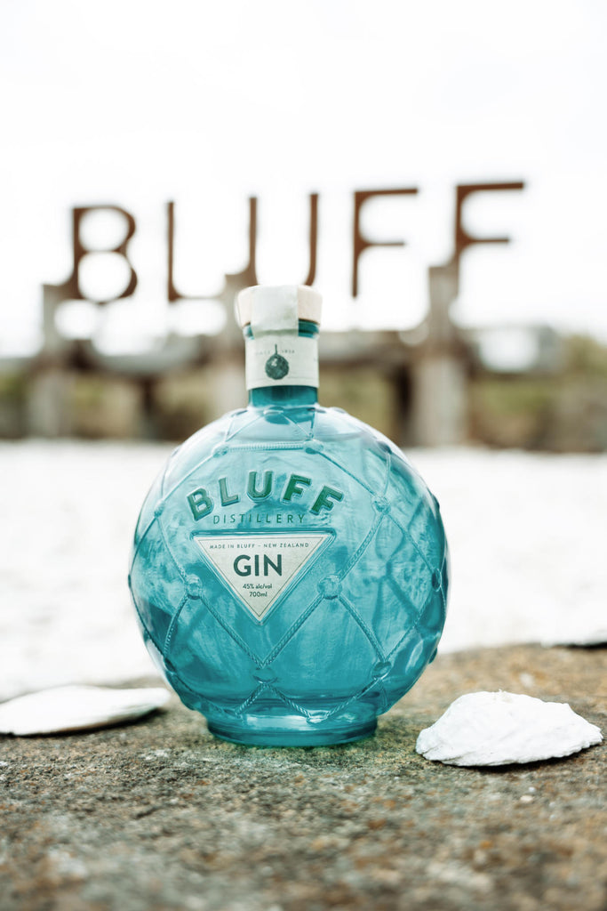 An image of a stunning and unique bottle of Bluff London Dry style gin, 700ml with the iconic Bluff City sign in the background